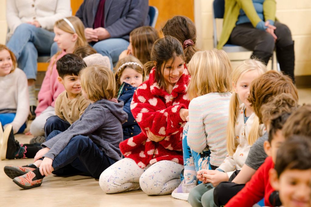 group of early childhood students smiling sitting on the floor