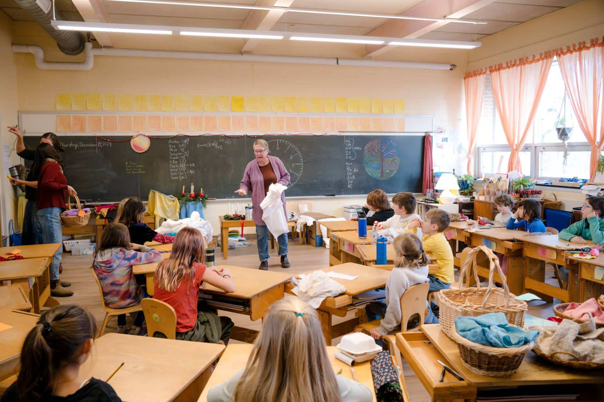 class of lower grades children with teacher in front