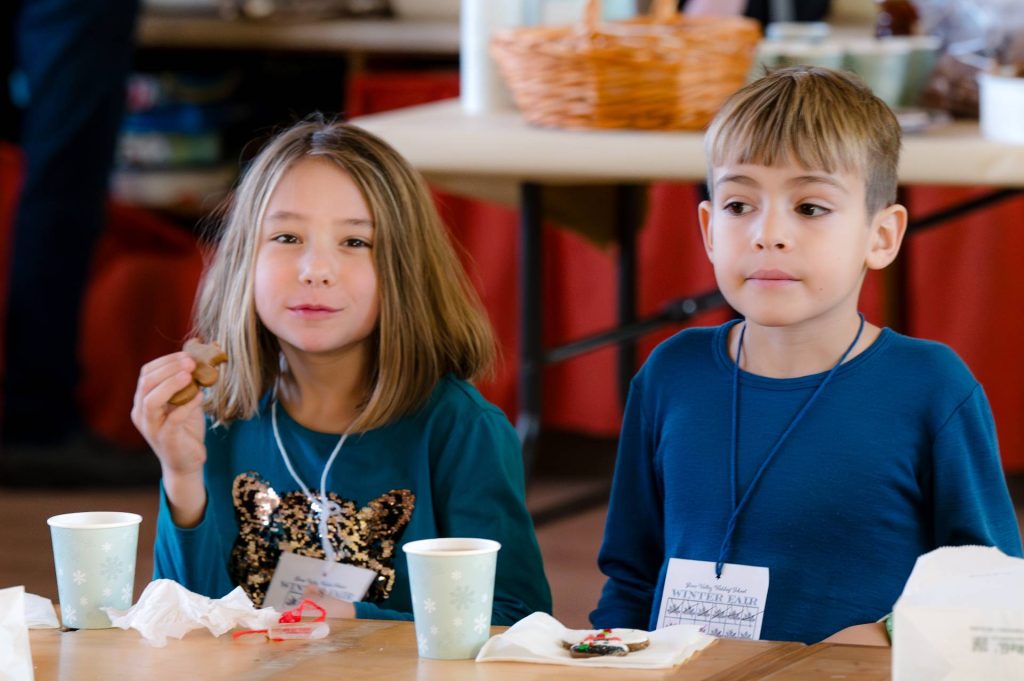 two first graders eating snacks at winter fair