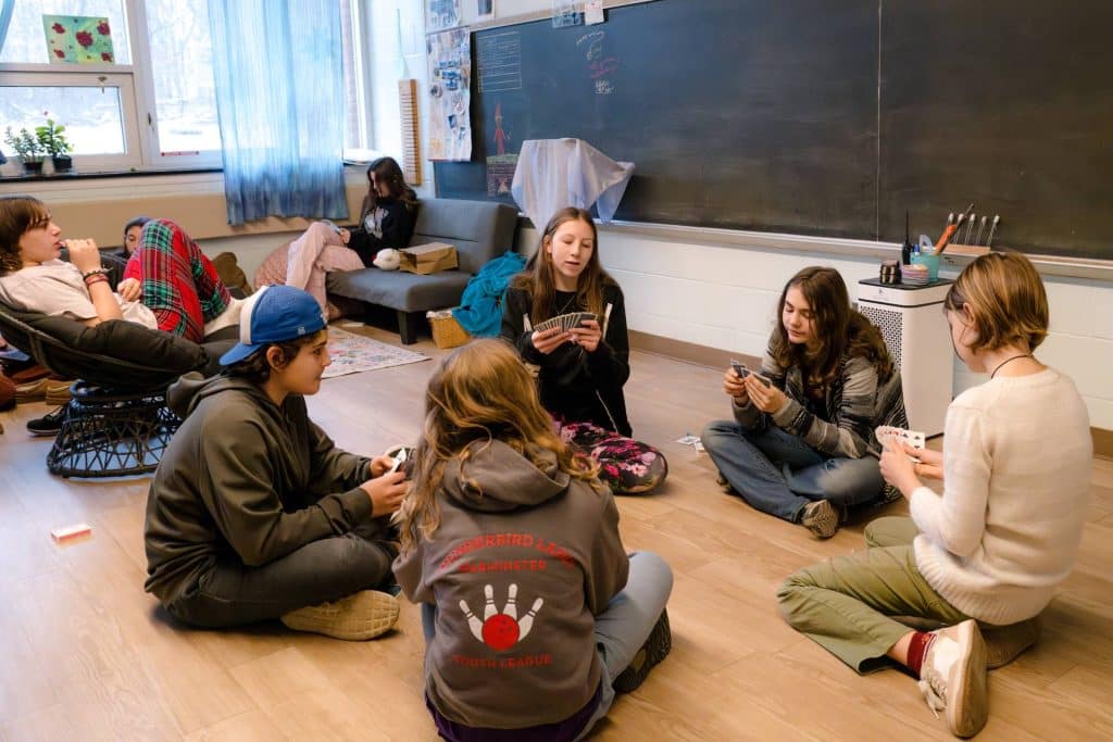 class of 7th graders sitting in a circle on the floor