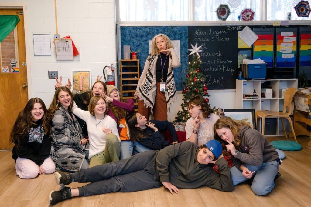 class of middle school students smiling for a photo