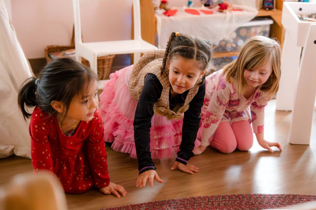 3 girls in early childhood class kneeling and playing