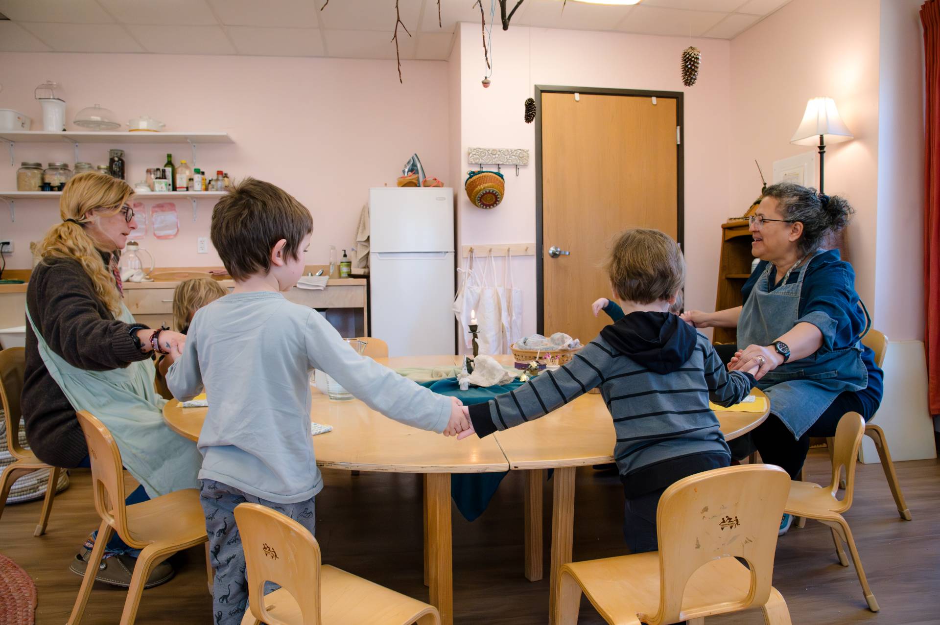 early childhood students and teachers holding hands in a circle