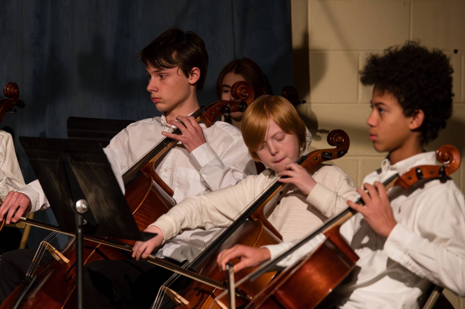 group of middle schools playing string instruments in orchestra
