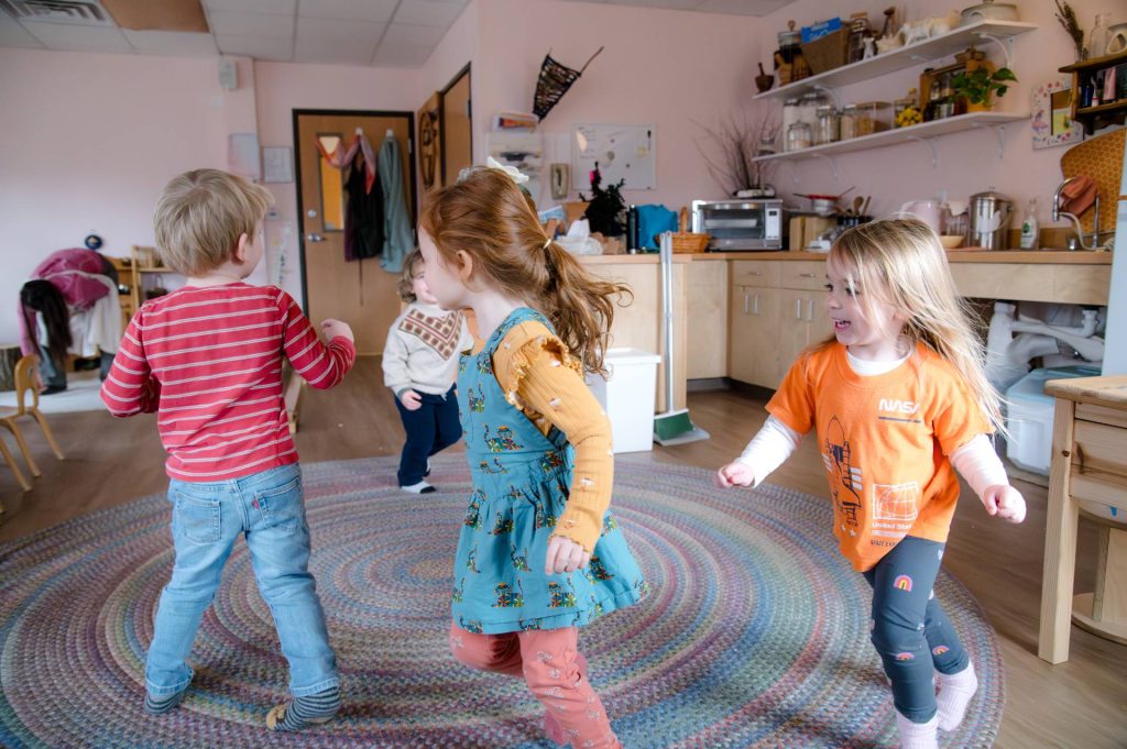 early childhood students running in a circle in classroom