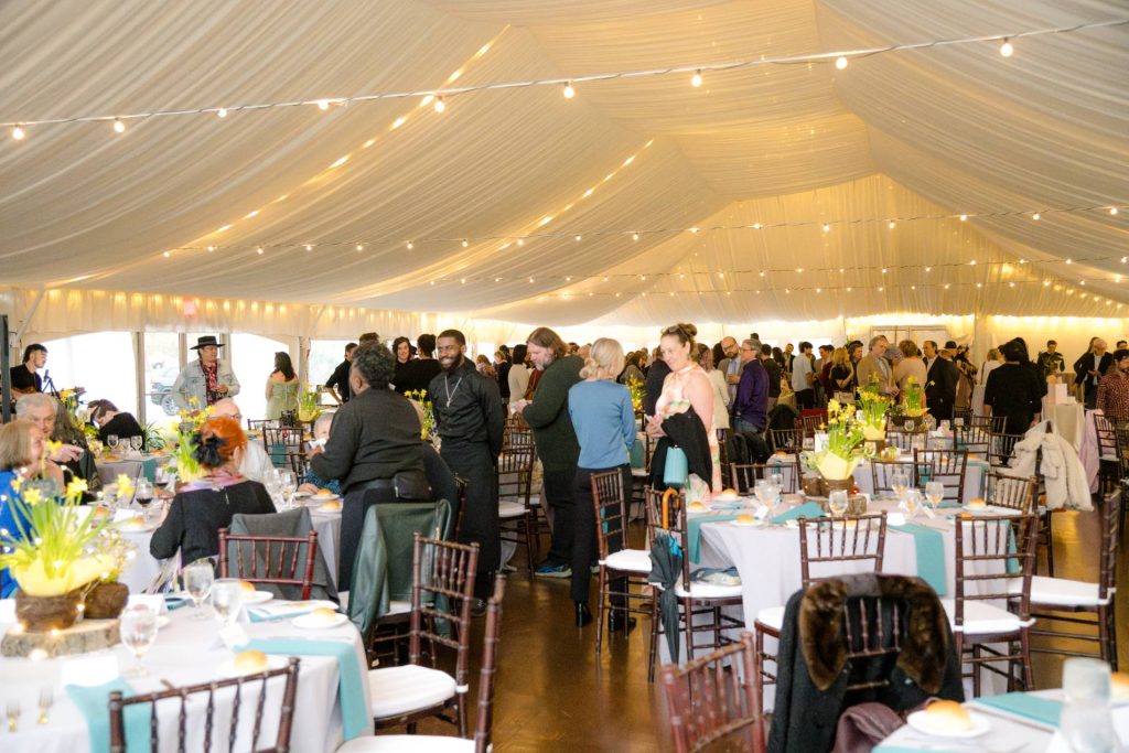 large room full of well-dressed people for annual auction