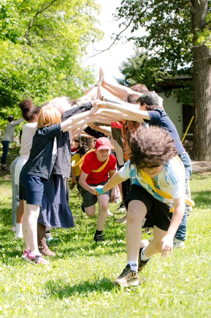 students forming a tunnel with their hands and other students running beneath it
