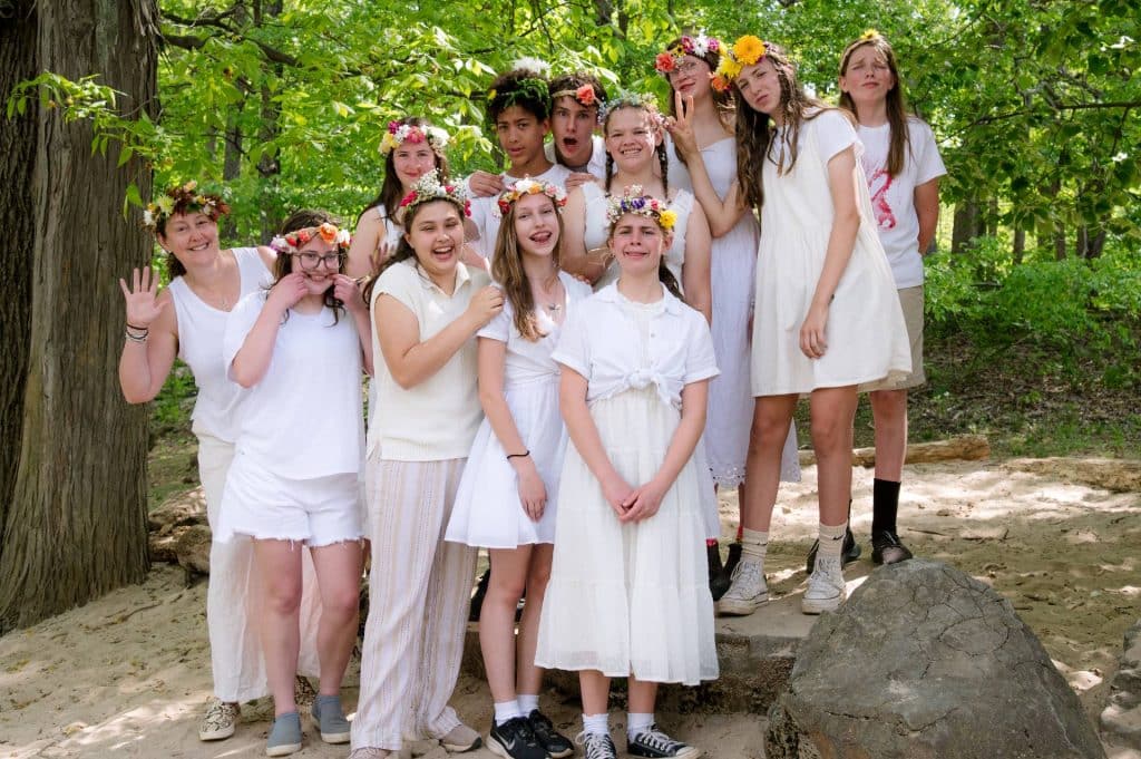 eighth grade class posing together in white clothes on mayfair day