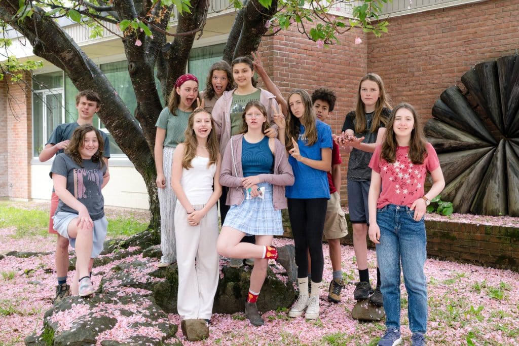 group of middle school students next to a tree