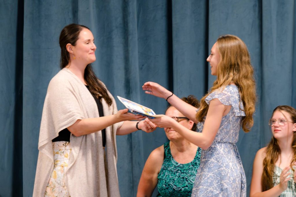 female student receiving diploma on graduation day