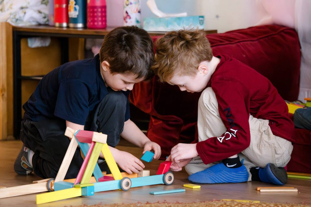 early childhood boy students playing with blocks