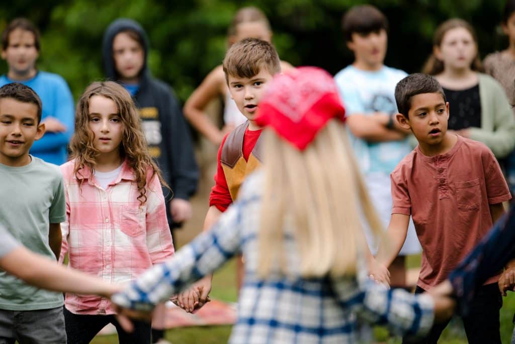 first grade students holding hands and running in a circle