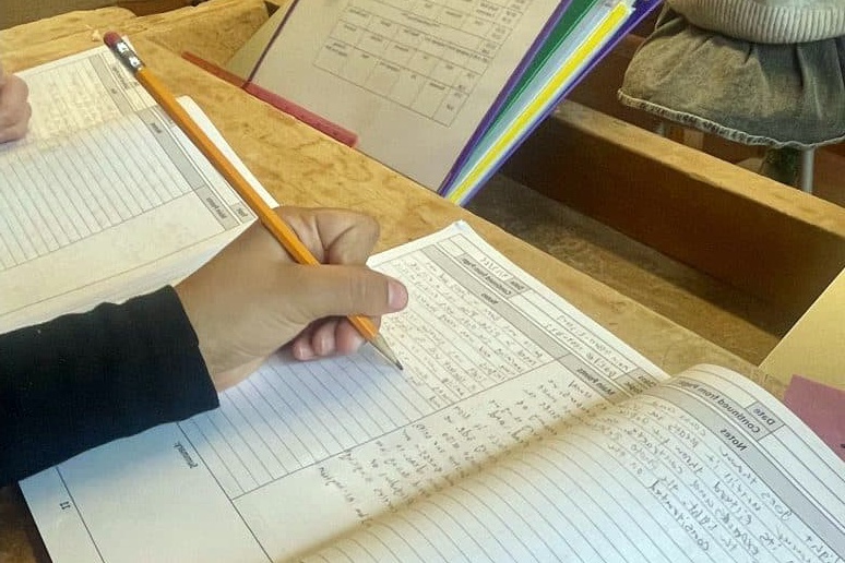 female student holding a pencil and writing on a work sheet