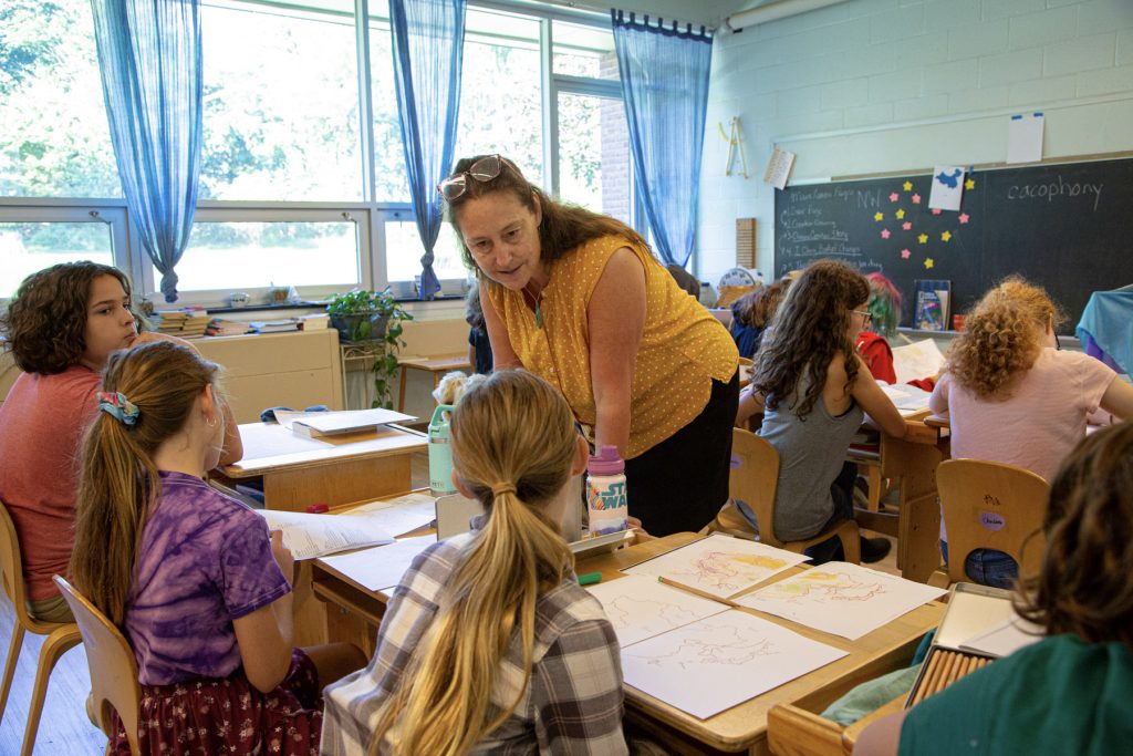 teacher with a group of lower grades students in a classroom