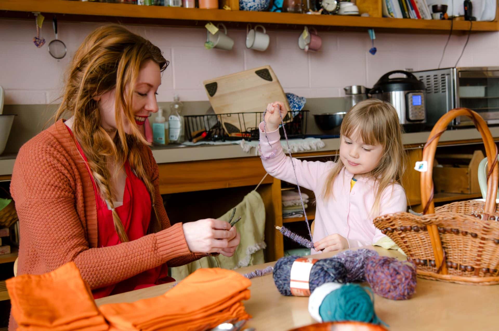 ealry childhood teacher doing crochet with female student