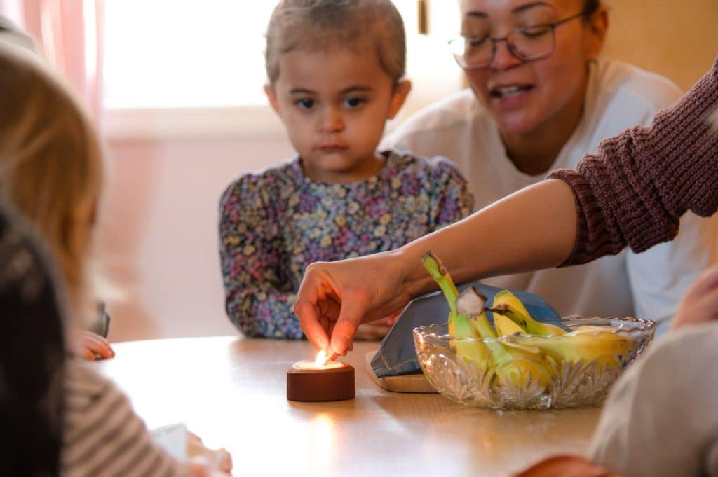 group of early childhood students with a candle on the table