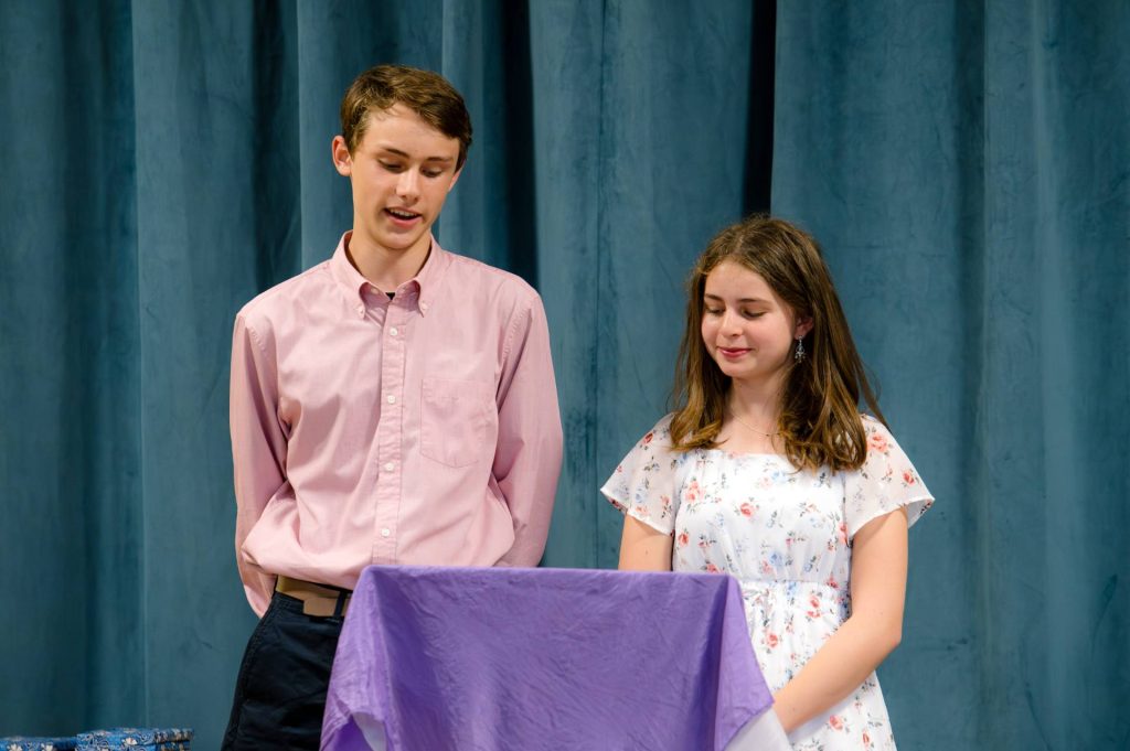 boy and girl middle school students on stage together