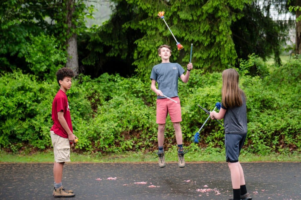 three middle school students playing games outside on blacktop
