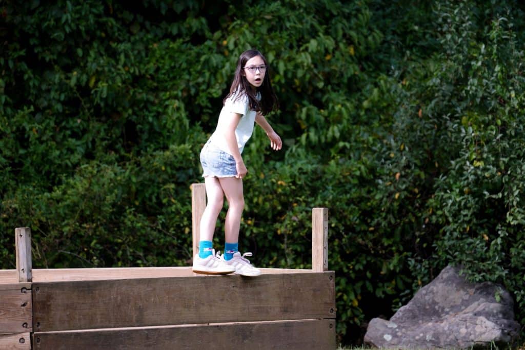 female student standing on a wooden platform outside